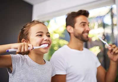 Father Daughter Brushing Teeth Together